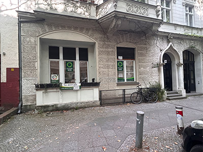 Ein typischer Büroraum, mit Schreibtischen, Bildschirmen und Bildern an der Wand.